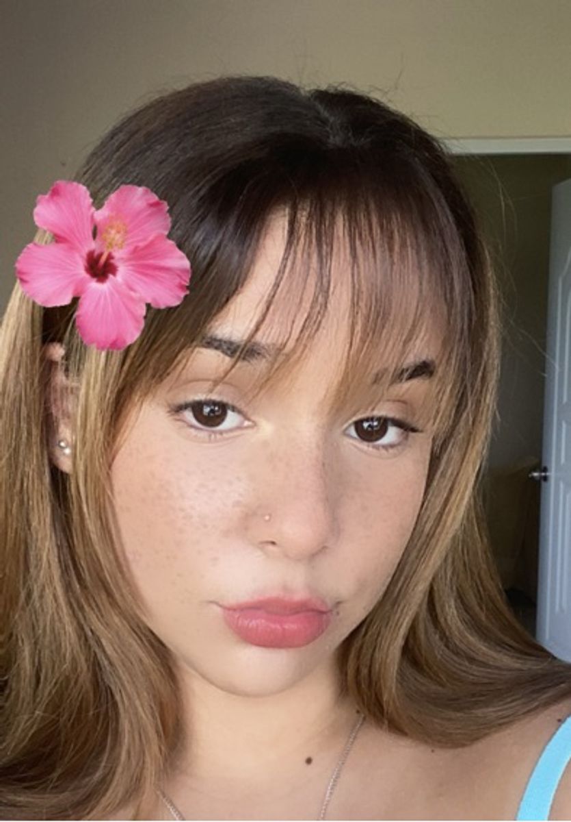 A woman wearing a pink flower in her hair